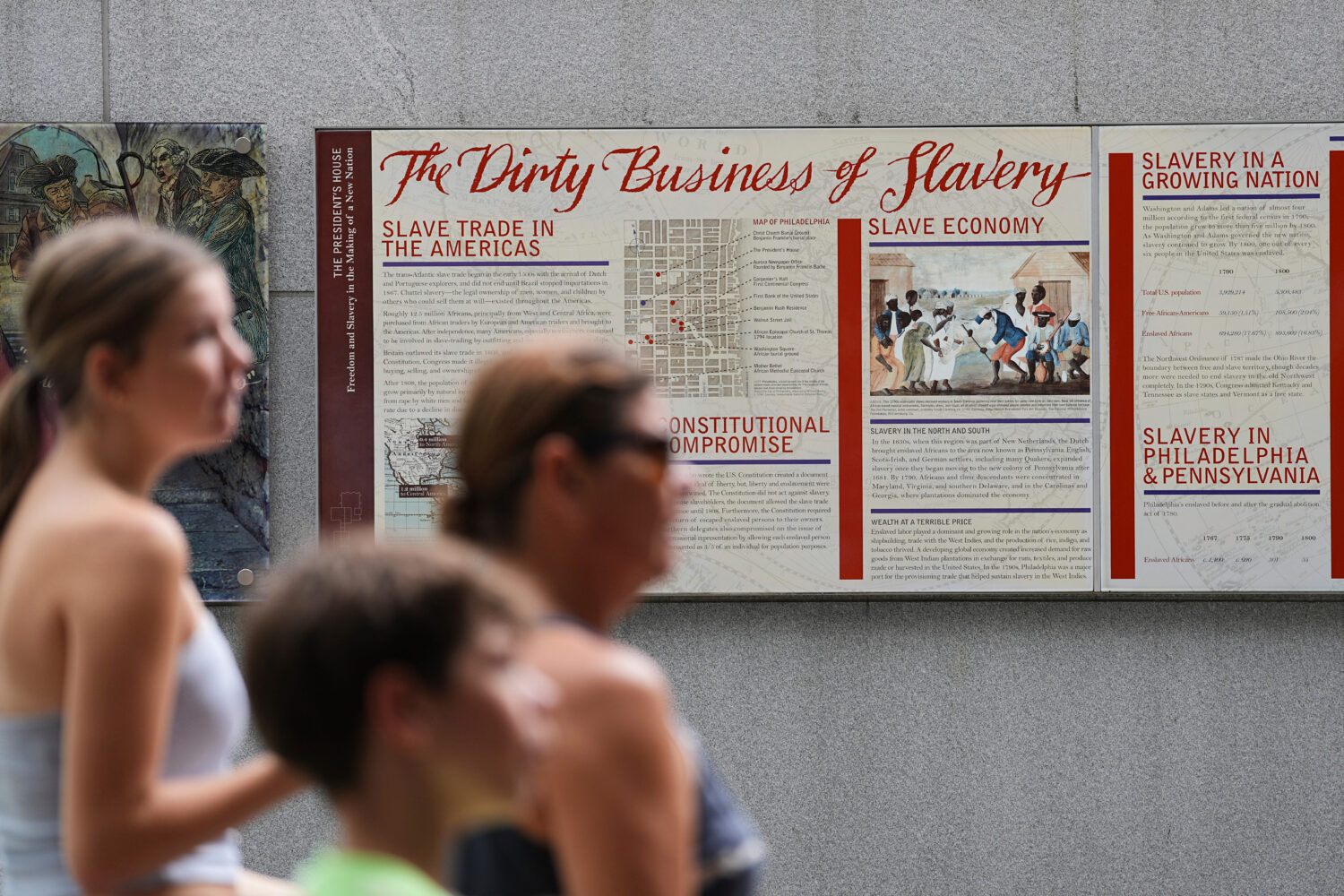 FILE - People walk past an informational panel at President's House Site Tuesday, Aug. 19, 2025, in...