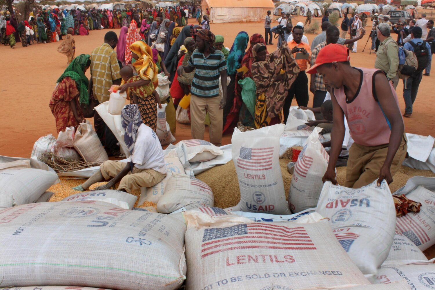 FILE - Workers distribute food aid from the World Food Program at a refugee camp in Dolo, Somalia o...