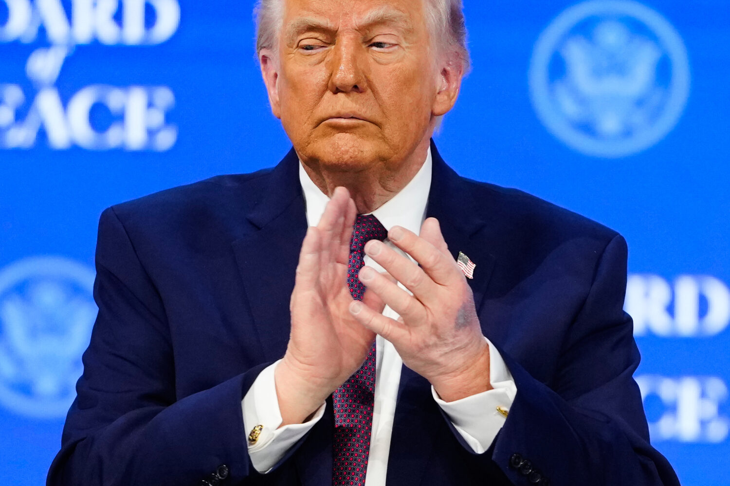 President Donald Trump applauses during a signing ceremony on his Board of Peace initiative at the ...