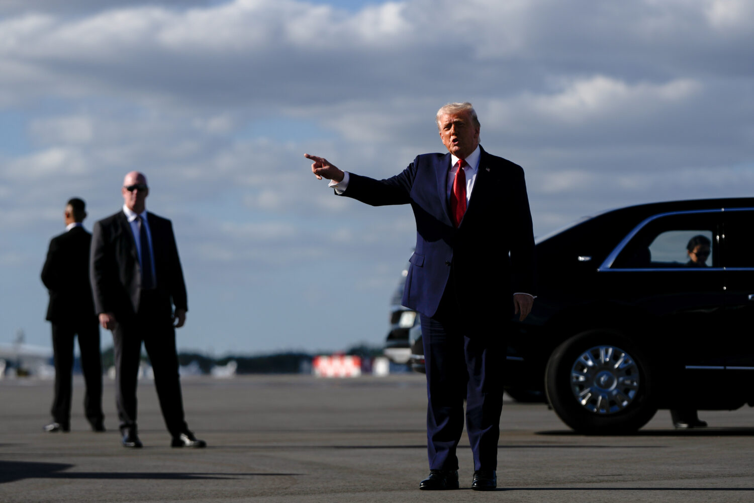 President Donald Trump points after arriving at Palm Beach International Airport on Air Force One, ...