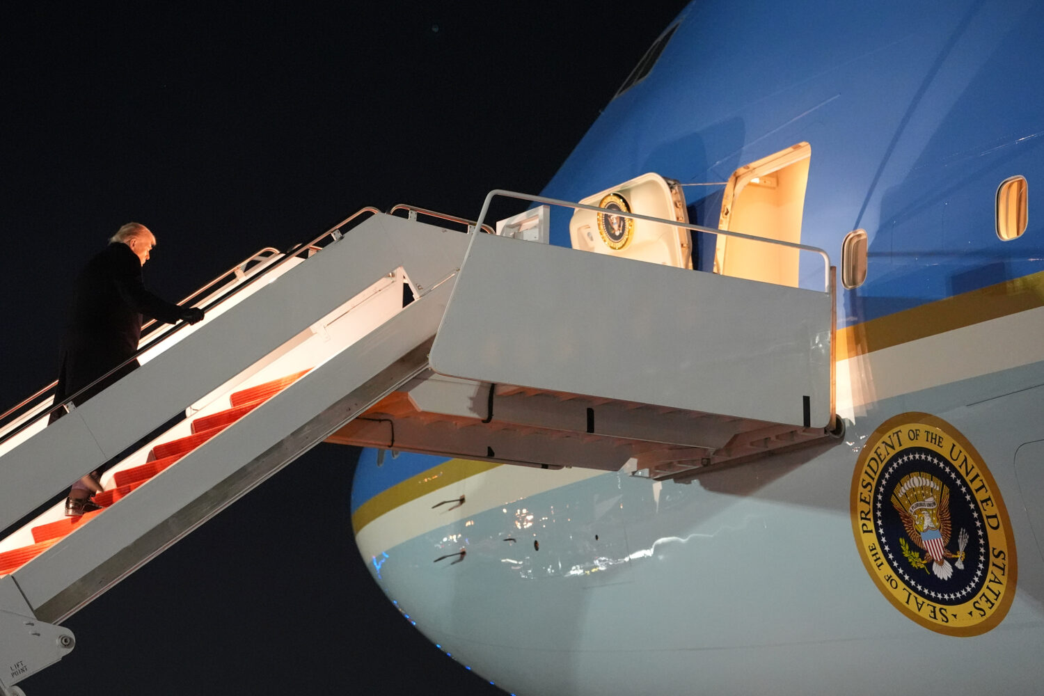 President Donald Trump boards Air Force One for a trip to attend the World Economic Form in Davos, ...