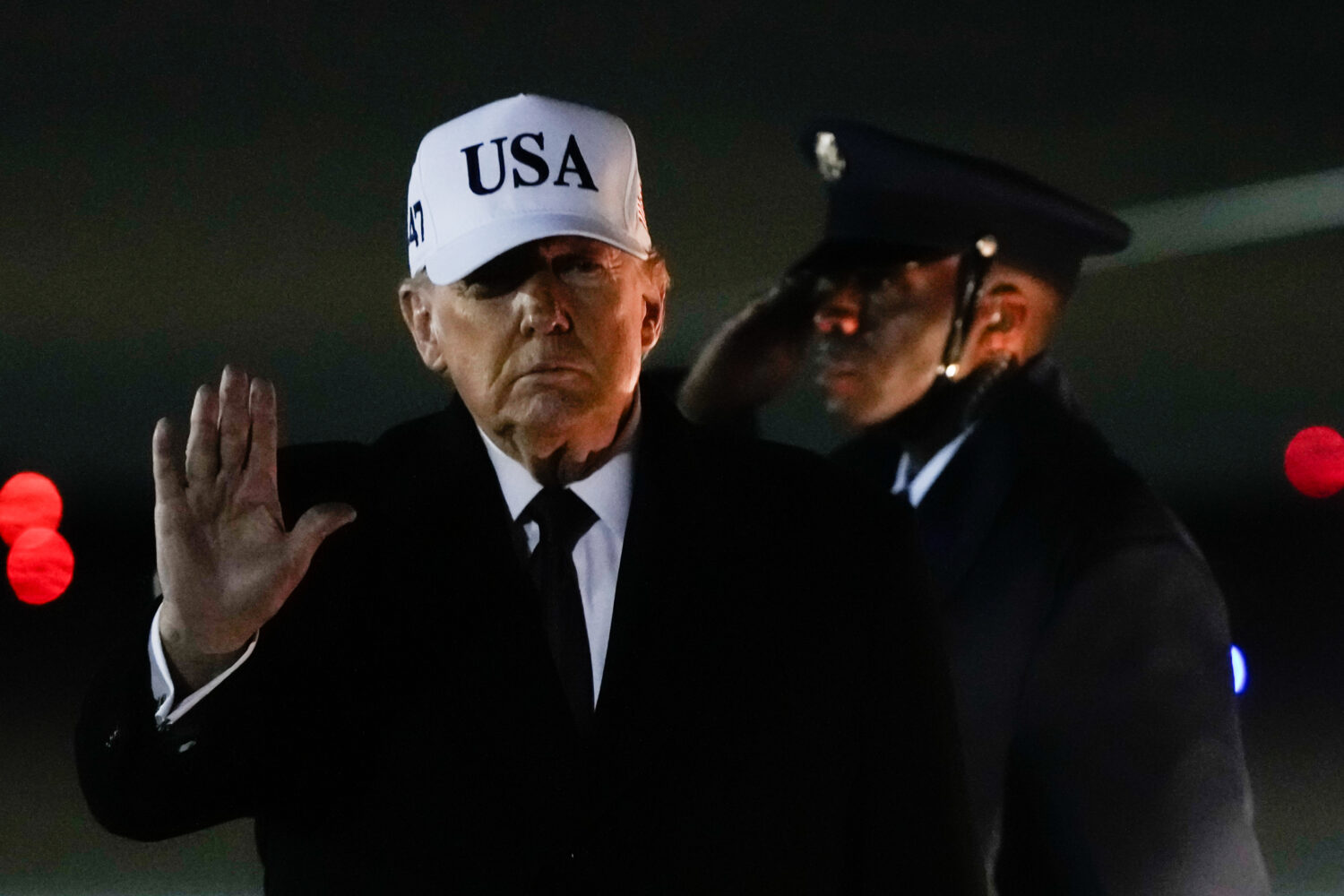 President Donald Trump waves after arriving on Air Force One from Florida, Sunday, Jan. 11, 2026, a...