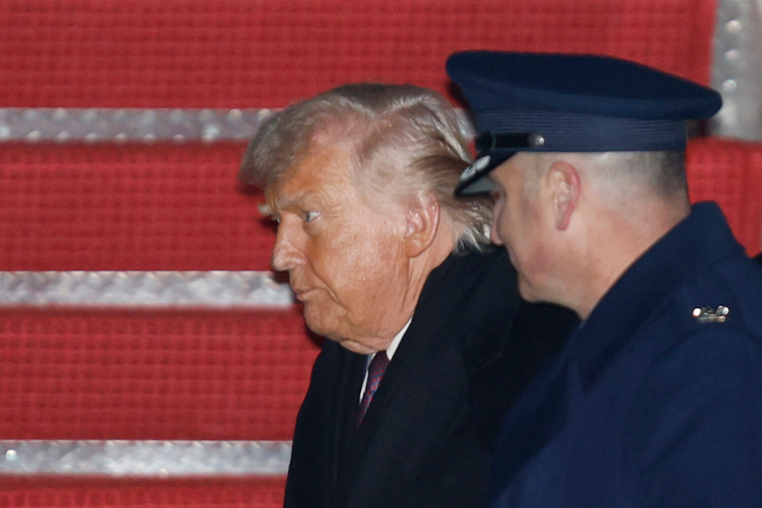 President Donald Trump, left, is greeted by Air Force Col. Christopher M. Robinson, commander of th...