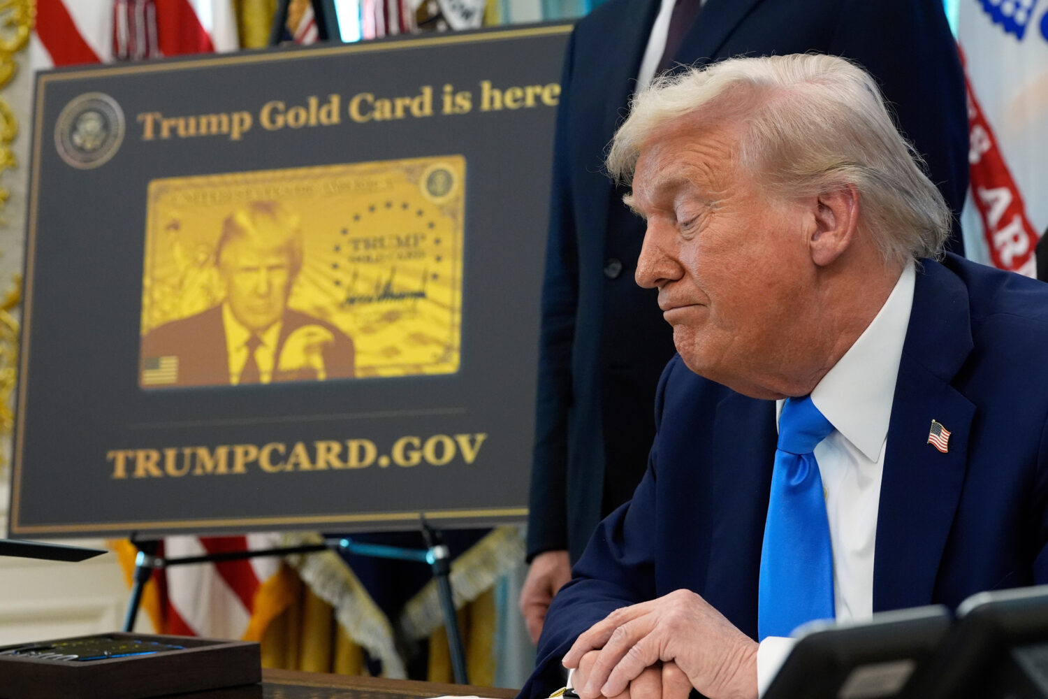 FILE - A poster showing the Trump Gold Card is seen as President Donald Trump signs executive order...