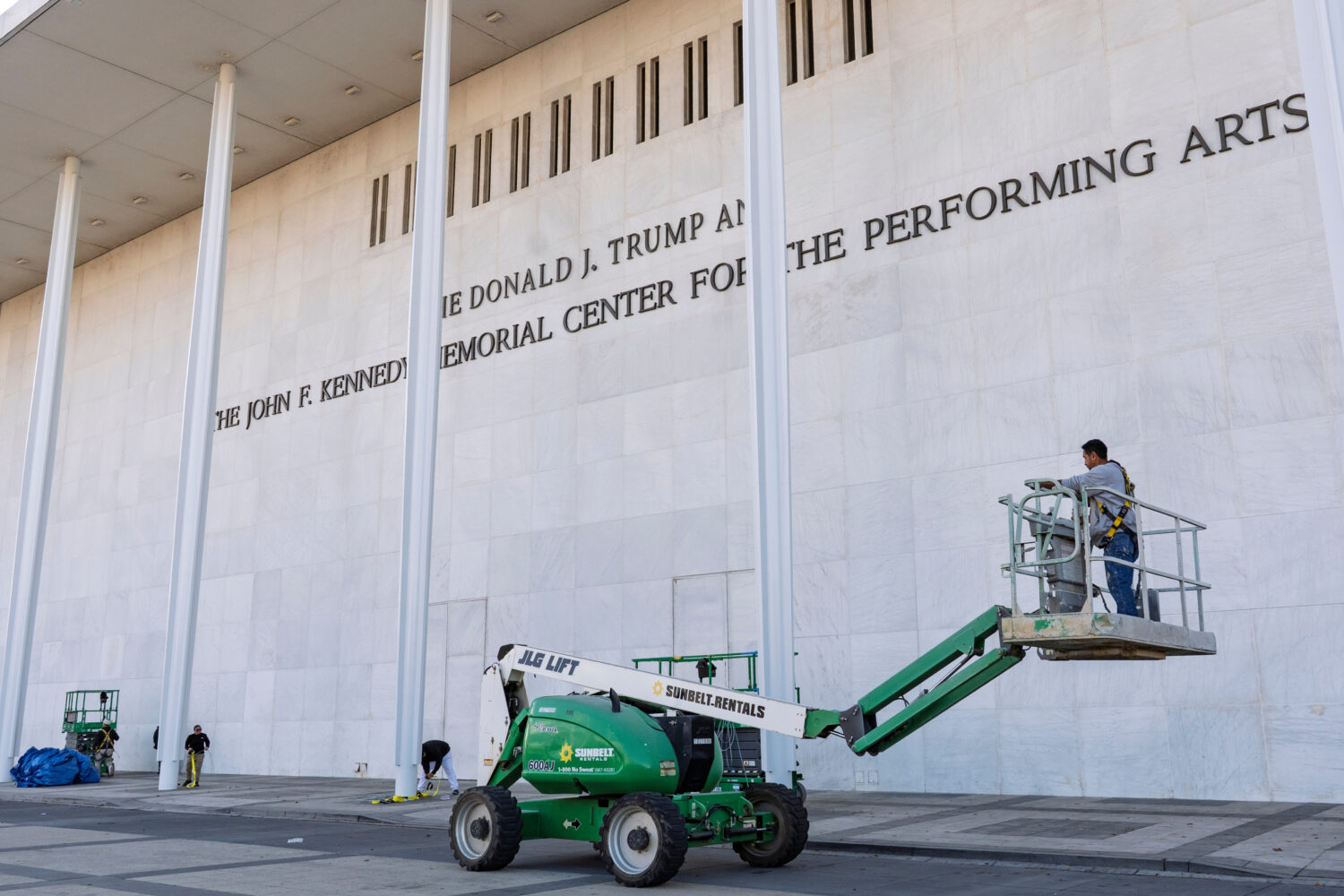 FILE - Workers add President Donald Trump's name to the John F. Kennedy Memorial Center for the Per...