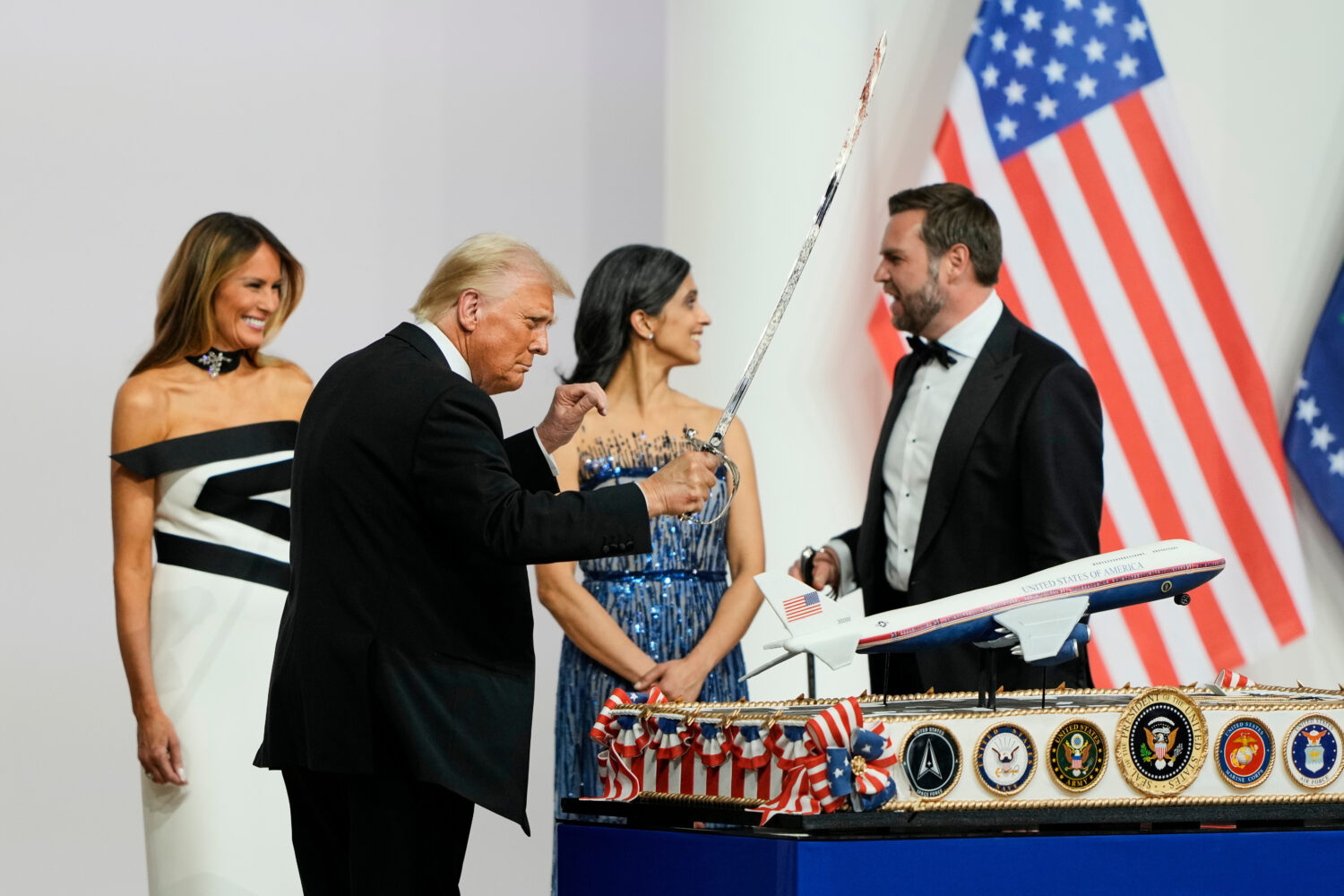 FILE - President Donald Trump holds a saber after using it to cut a cake at the Commander in Chief ...
