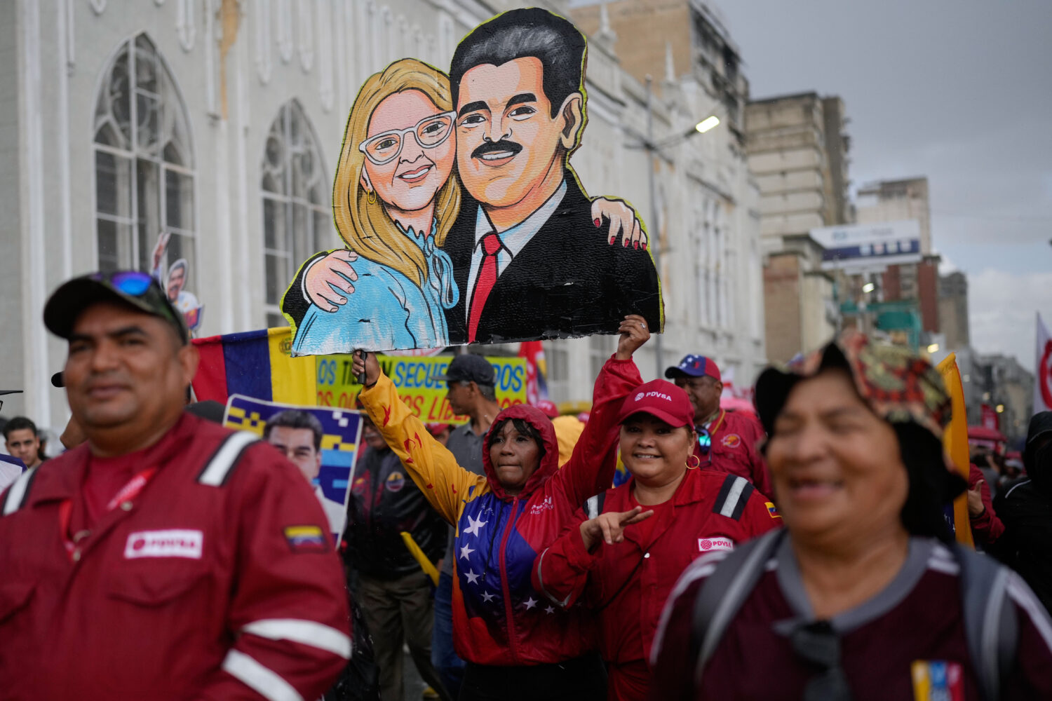 Government supporters carry a cutout of former President Nicolás Maduro and his wife Cilia Flores ...