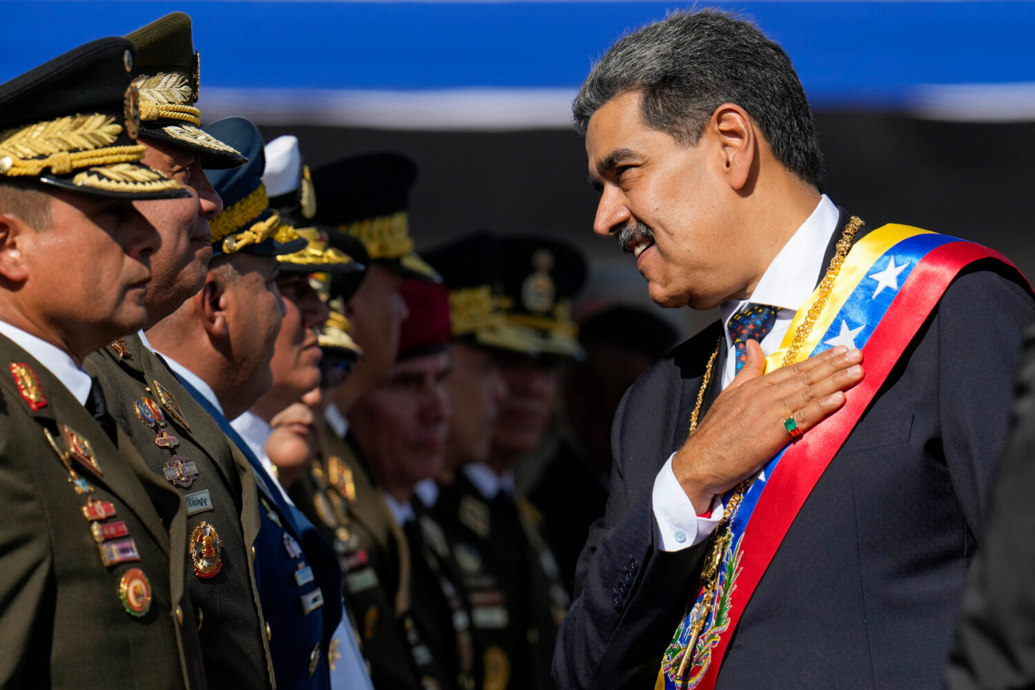 FILE - Venezuela's President Nicolas Maduro places his hand over his hear while talking to high-ran...