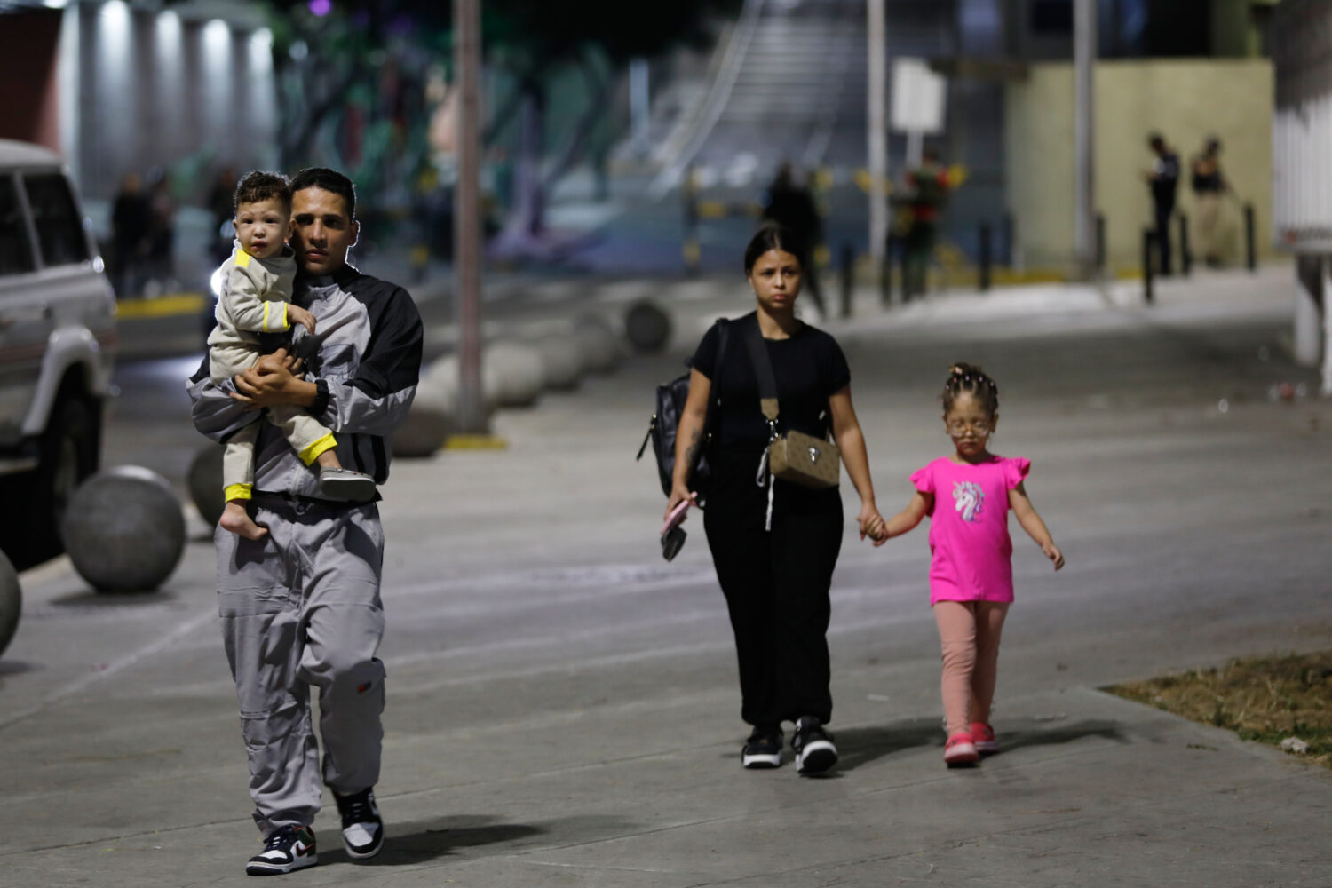 Pedestrians walk past the Miraflores presidential palace after explosions and low-flying aircraft w...