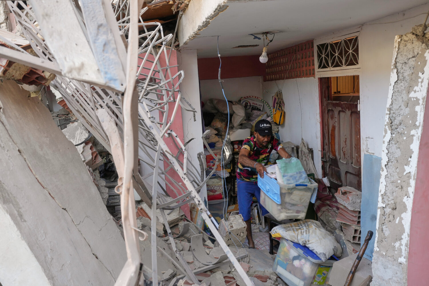 Jonathan Mayoral helps relatives clean up their apartment, which residents say was damaged during U...