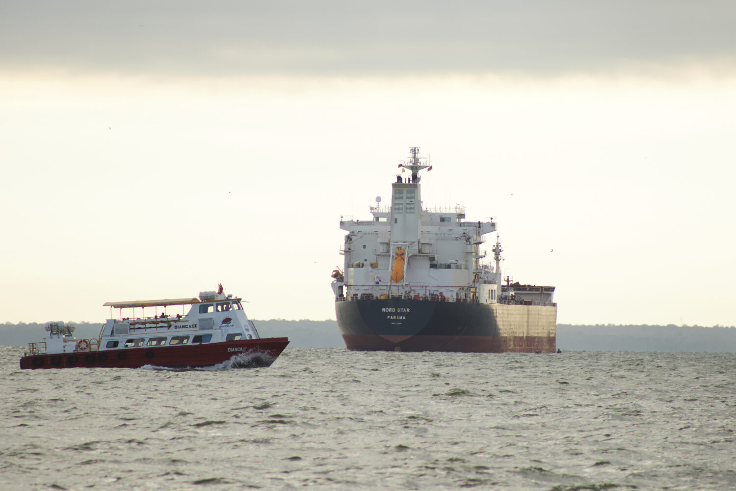 A boat sails past the oil tanker Nord Star, Panama, on Lake Maracaibo, Venezuela, Wednesday, Jan. 7...