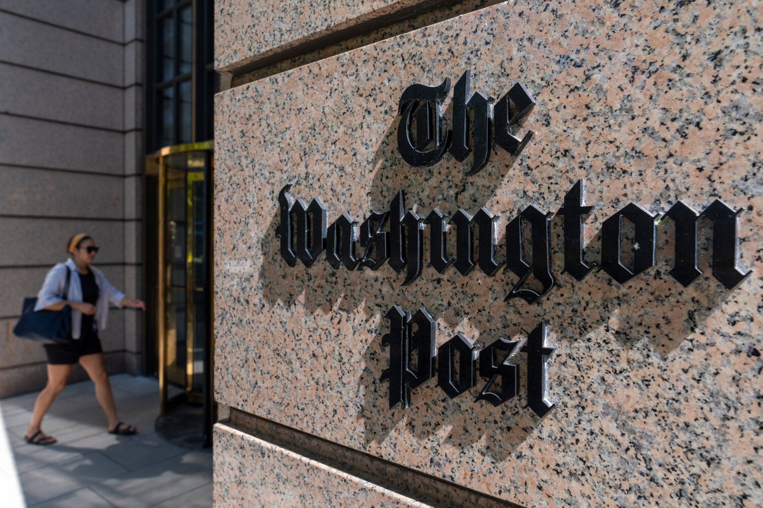 FILE - A person walks into the One Franklin Square Building, home of The Washington Post newspaper,...