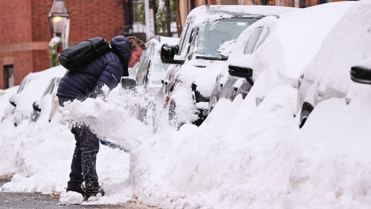A man digs out his car on Beacon Hill following a winter storm that dump more than a foot of snow a...
