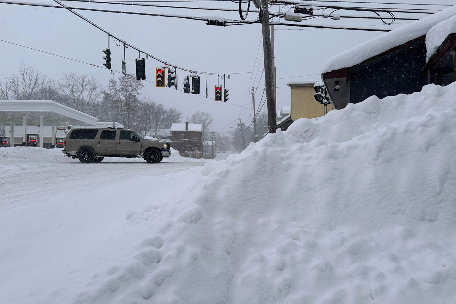 Traffic passes piled-up snow in Lowville, N.Y., Tuesday, Jan. 20, 2026. (AP Photo/Cara Anna)Credit:...