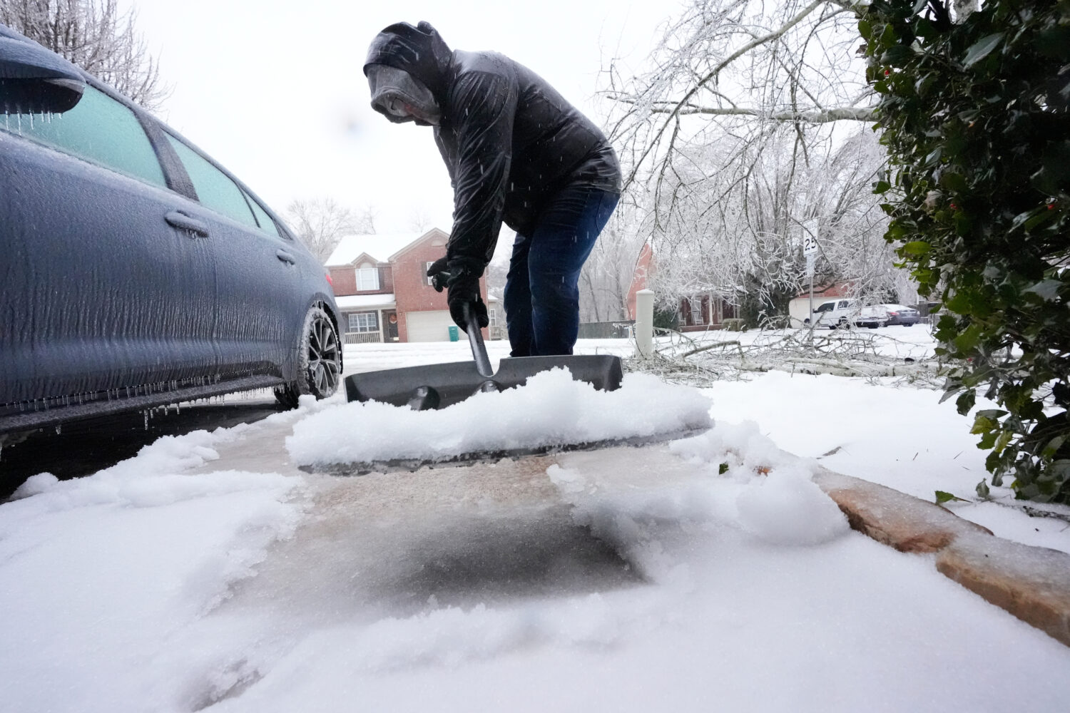 David Bentley shovels ice and snow from his driveway during a winter storm Sunday, Jan. 25, 2026, i...