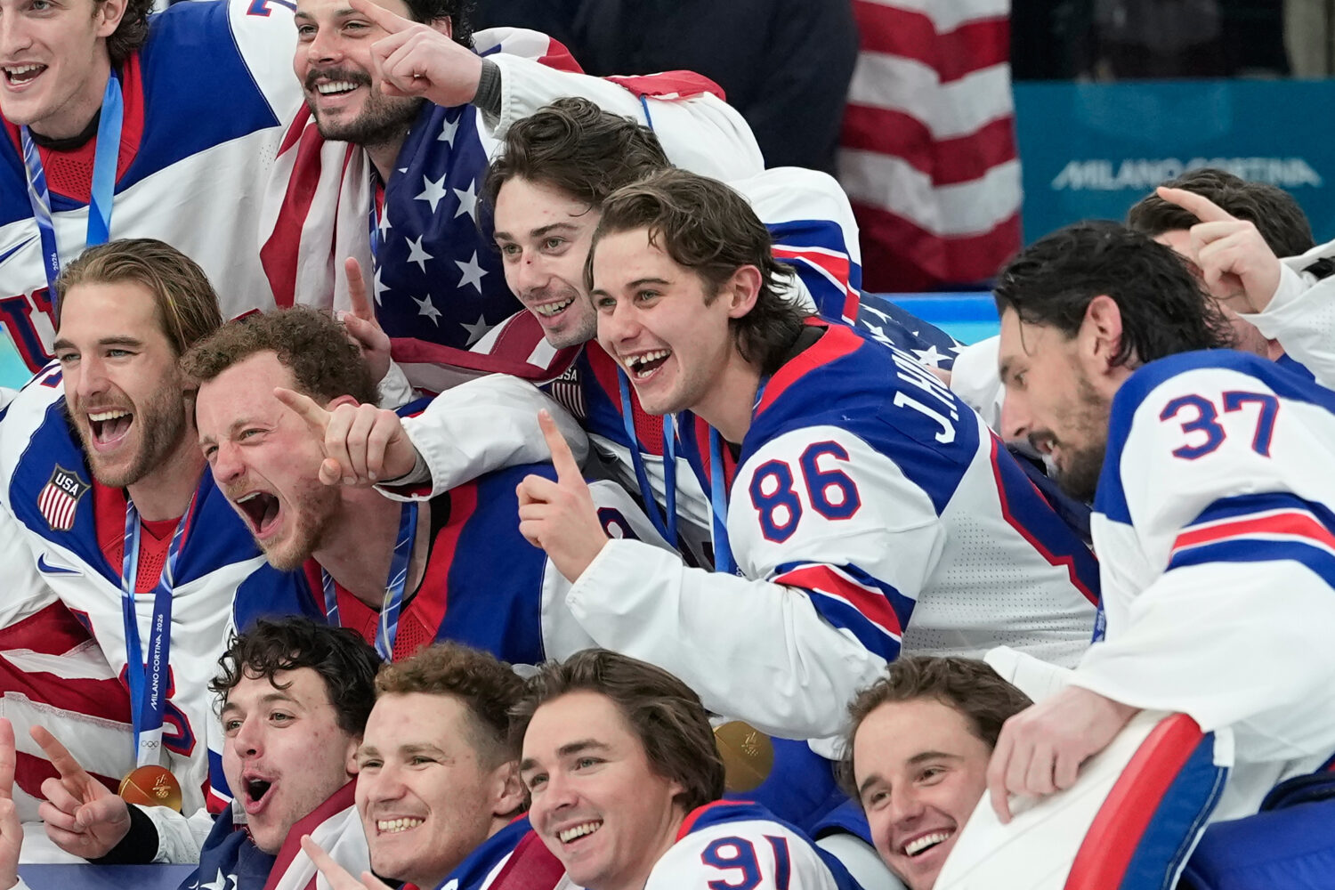 United States' Jack Hughes (86) poses with teammates after a men's ice hockey gold medal game betwe...