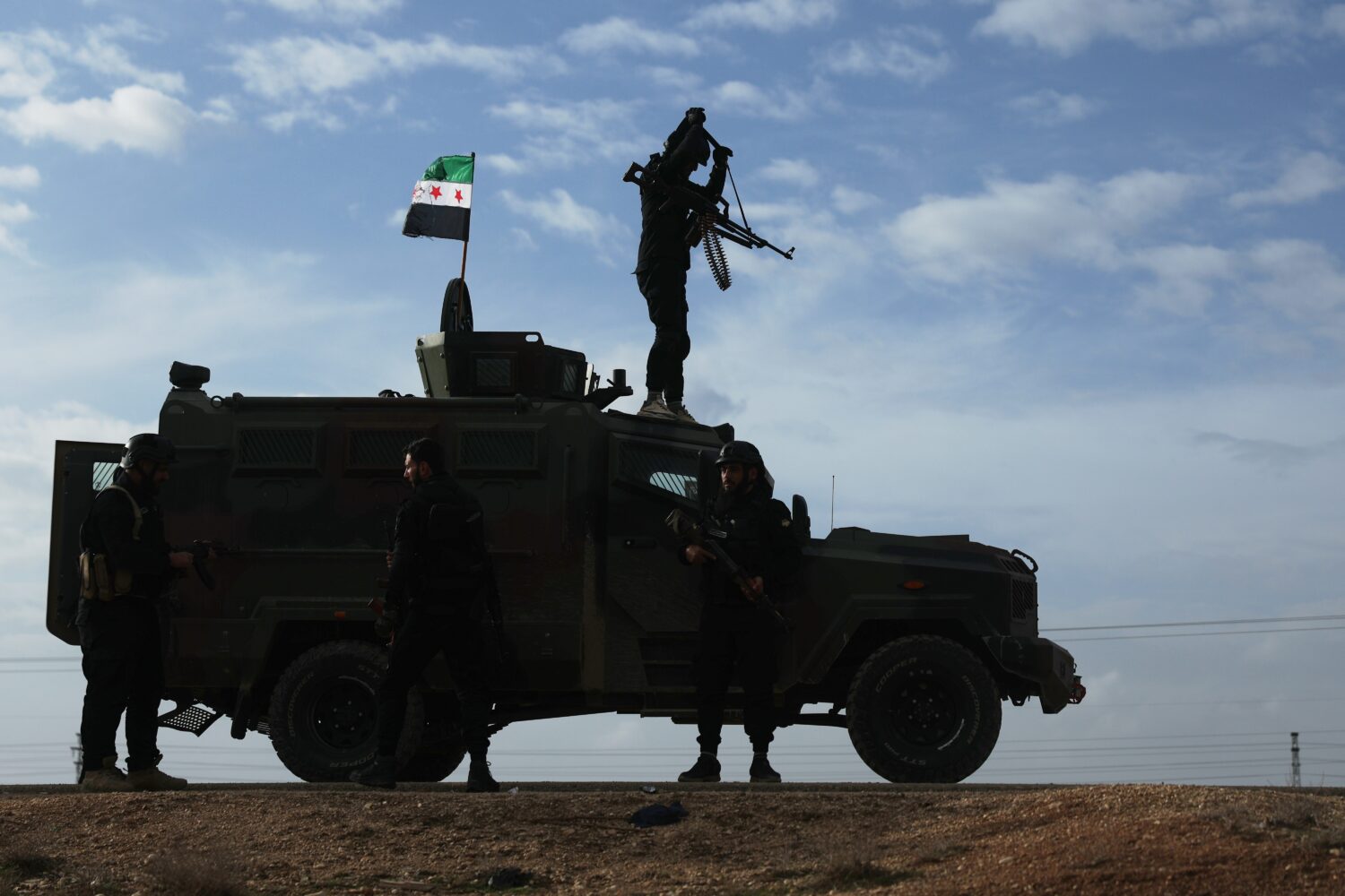 A vehicle pauses as a convoy of Syria's Interior Ministry forces passes through en route to the tow...
