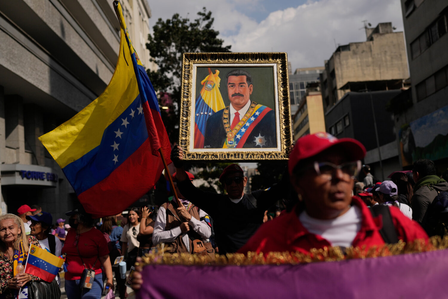 A government supporter holds an image of President Nicolas Maduro during a women's march to demand ...