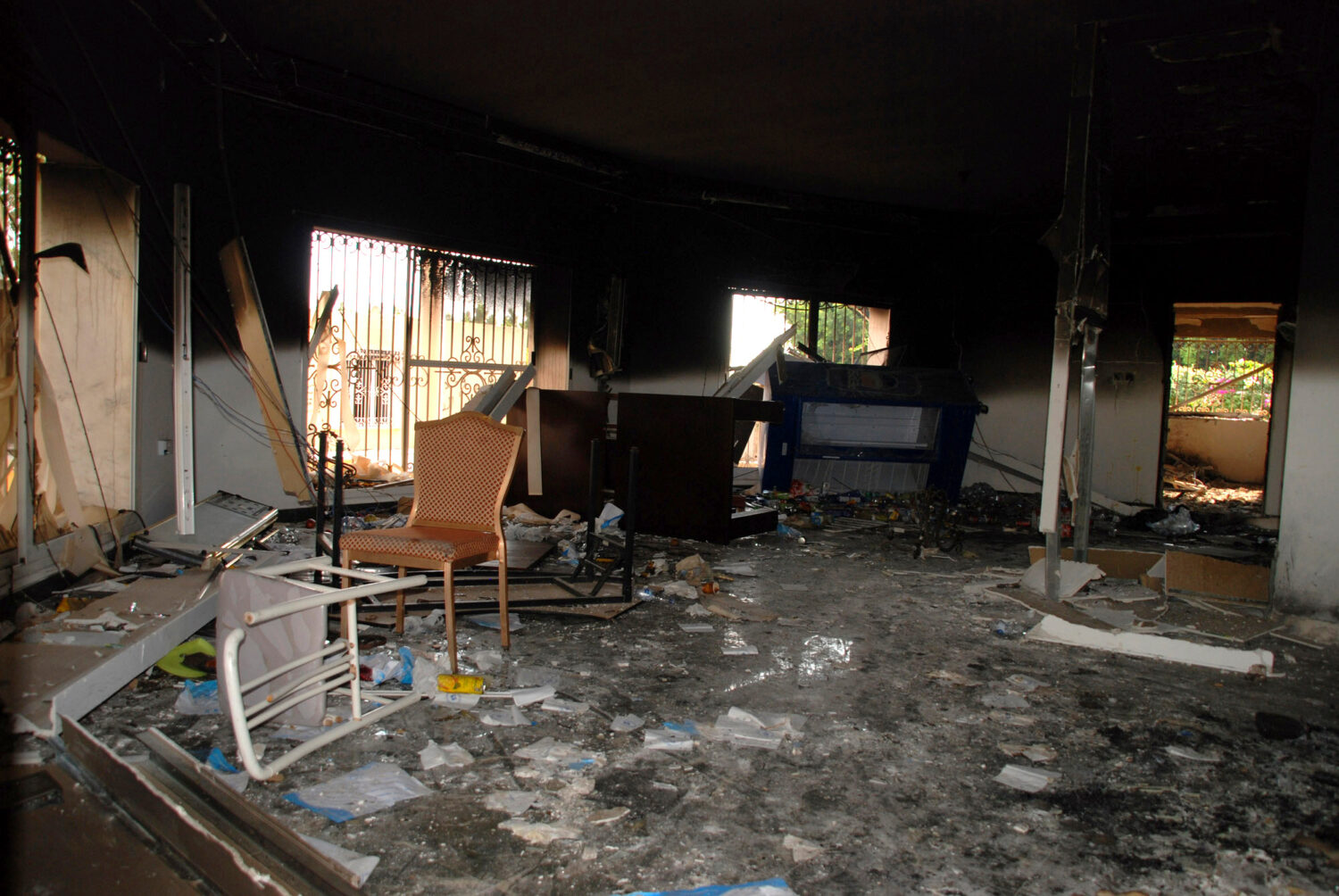 FILE - Glass, debris and overturned furniture are strewn inside a room in the gutted U.S. consulate...