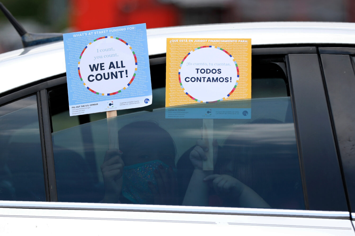 FILE - Two young children hold signs through the car window that make reference to the 2020 U.S. Ce...