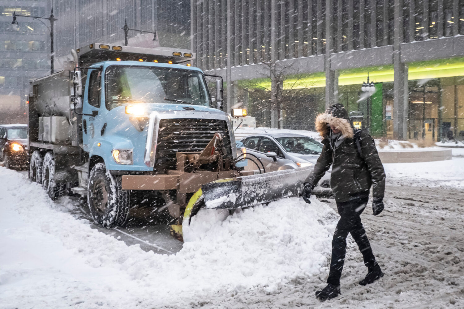 FILE - A man crosses Wacker Drive in front of a waiting city snowplow in Chicago, Jan. 28, 2019. (R...