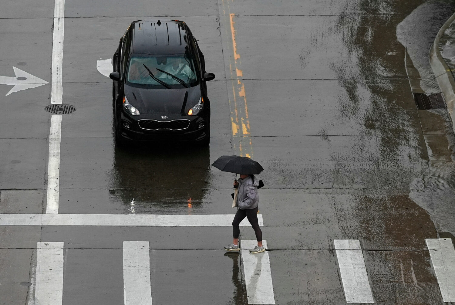 FILE - A pedestrian crosses the street in front of a car May 12, 2024, in Denver. (AP Photo/David Z...