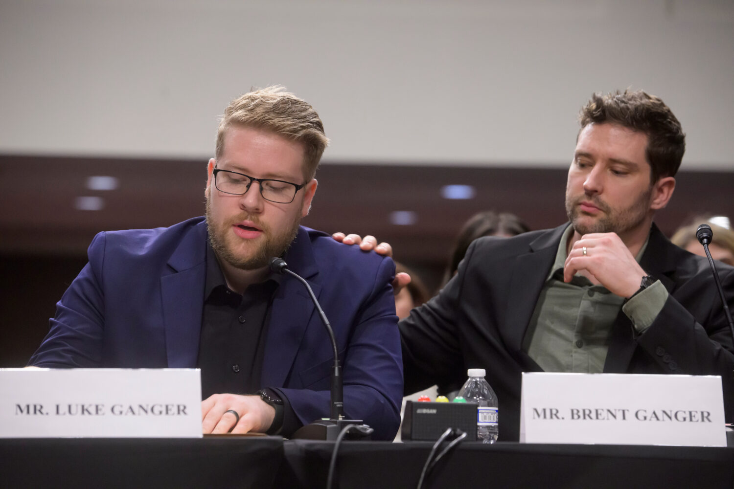Luke Ganger, left, and Brent Ganger, right, brothers of Renee Good, appear during a Bicameral Publi...