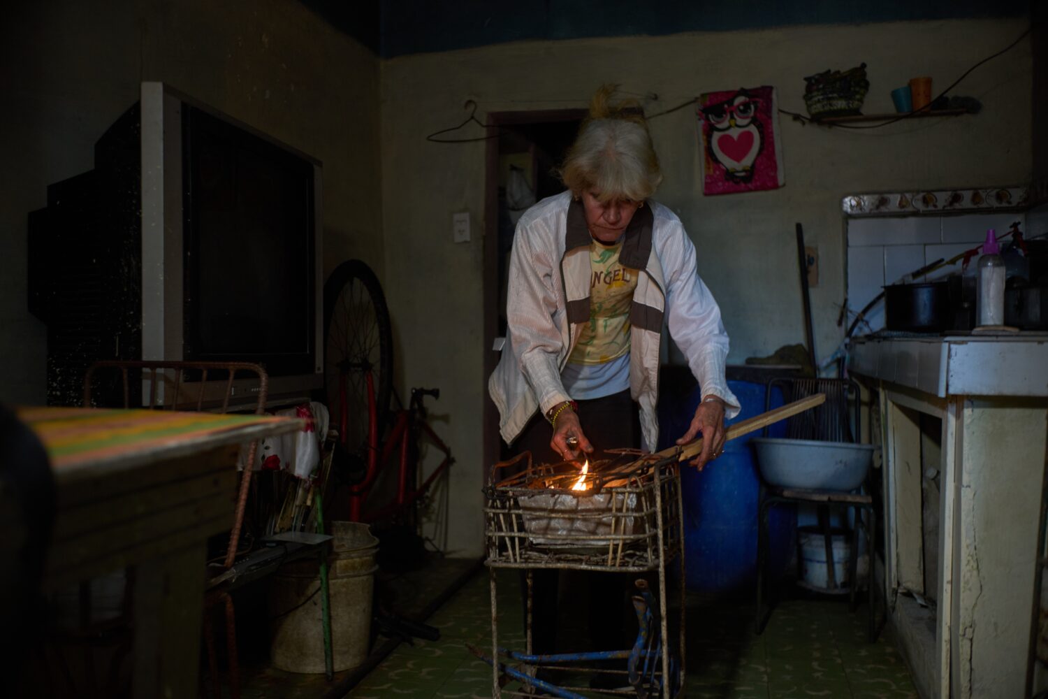 Minorkys Hoyos Ruiz lights coals to cook dinner during a scheduled blackout to ration energy in San...