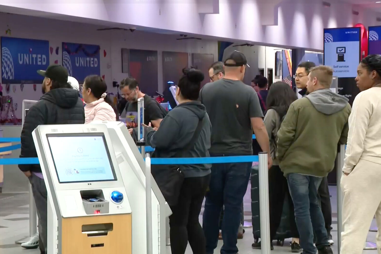 Passengers wait in line at the El Paso International Airport after all flights were grounded on Wed...
