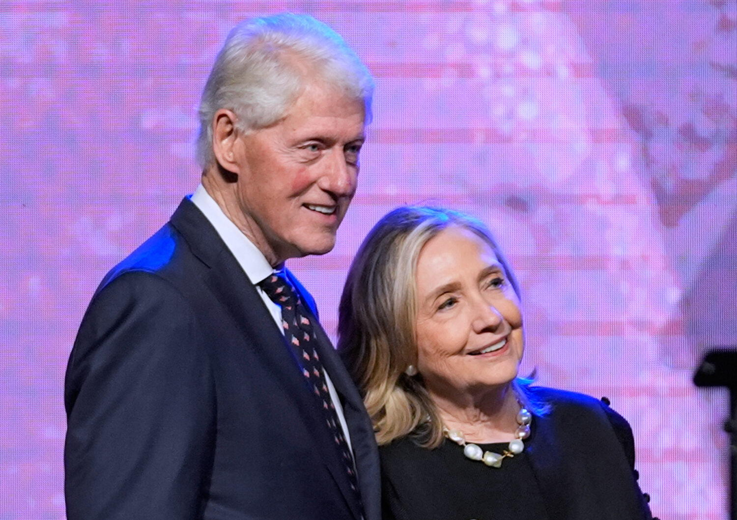 FILE - Former President Bill Clinton, left, and former Secretary of State Hillary Clinton listen as...