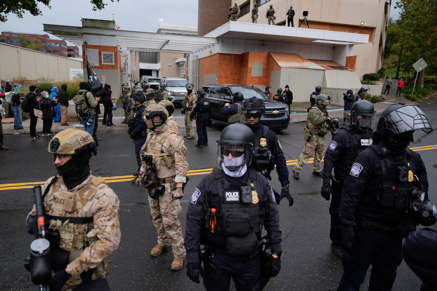 FILE - Law enforcement officers stand in the street to allow vehicles to leave a U.S. Immigration a...