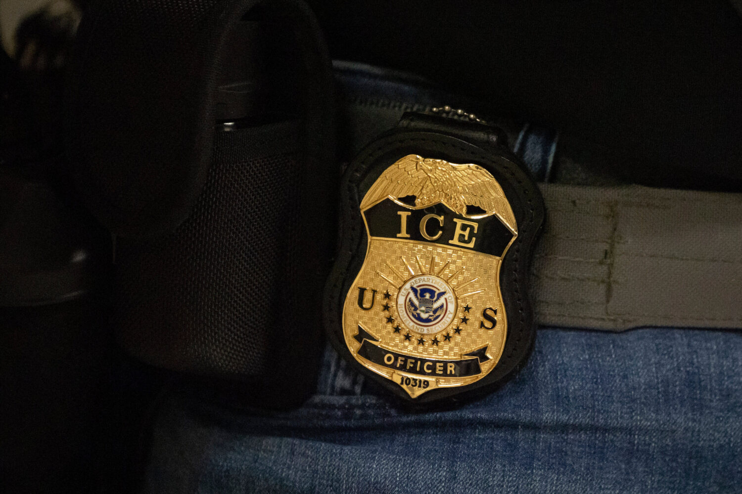 FILE - A federal agent wears a U.S. Immigration and Customs Enforcement badge in New York, June 10,...