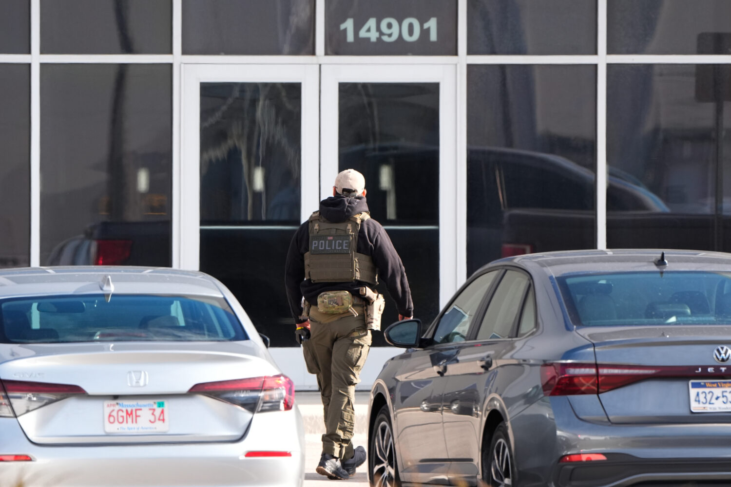 An ICE agent stands outside a warehouse as federal officials tour the facility to consider repurpos...