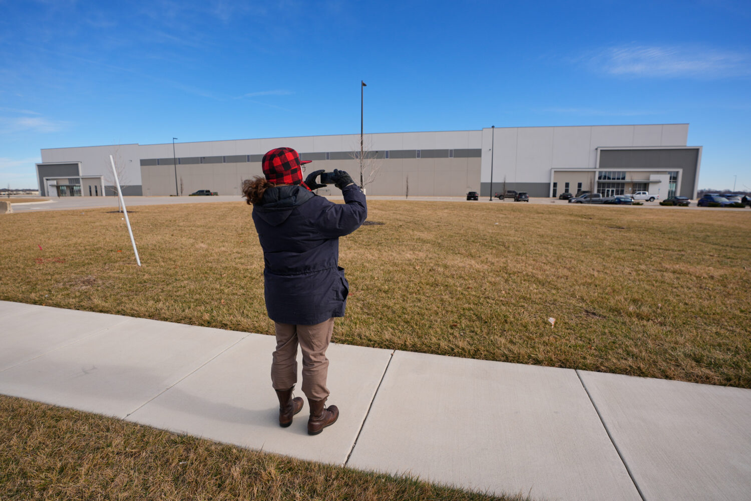 A man takes photos of a warehouse as federal officials tour the facility to consider repurposing it...