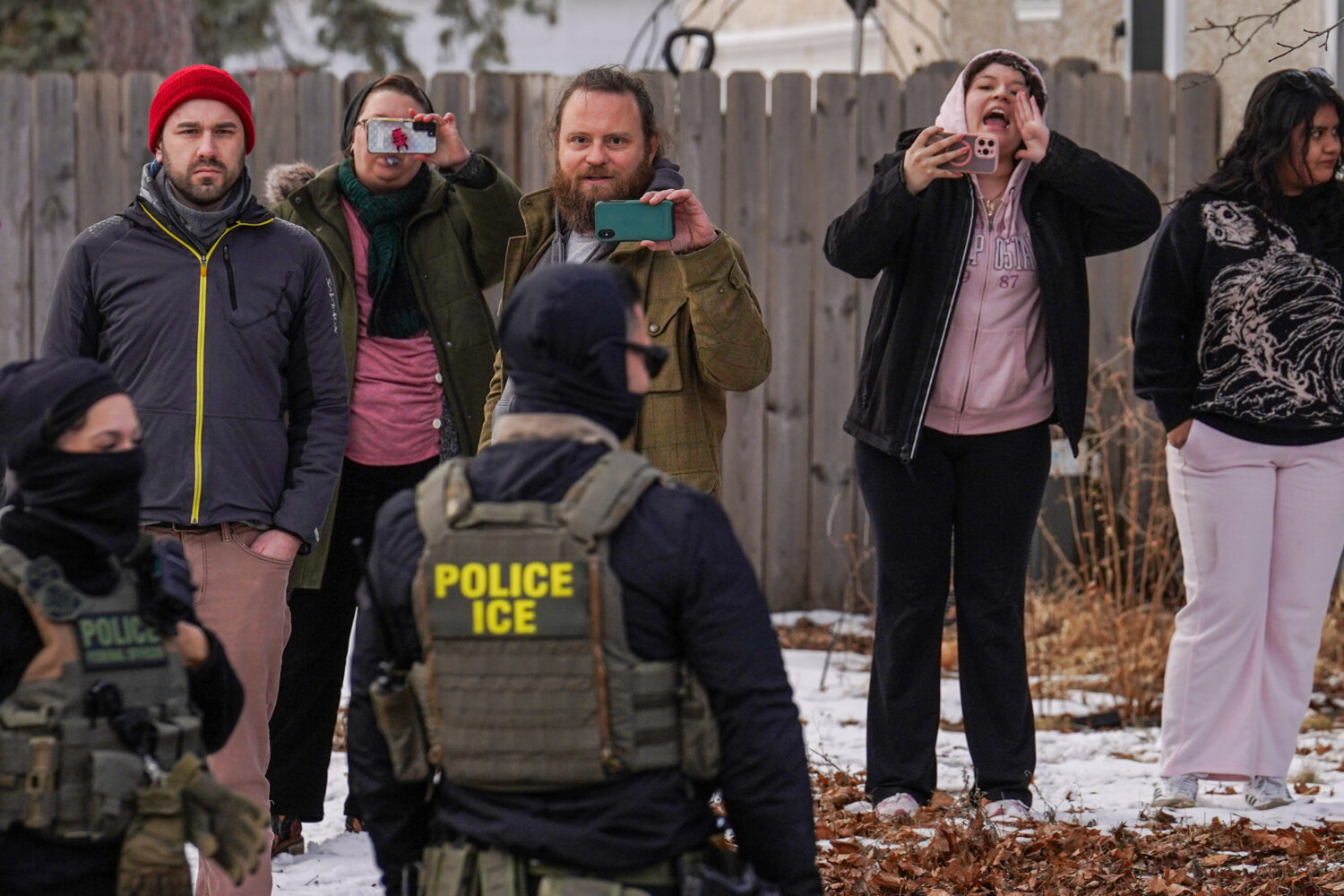 Observers film while federal agents conduct immigration enforcement operations, on Thursday, Feb. 5...