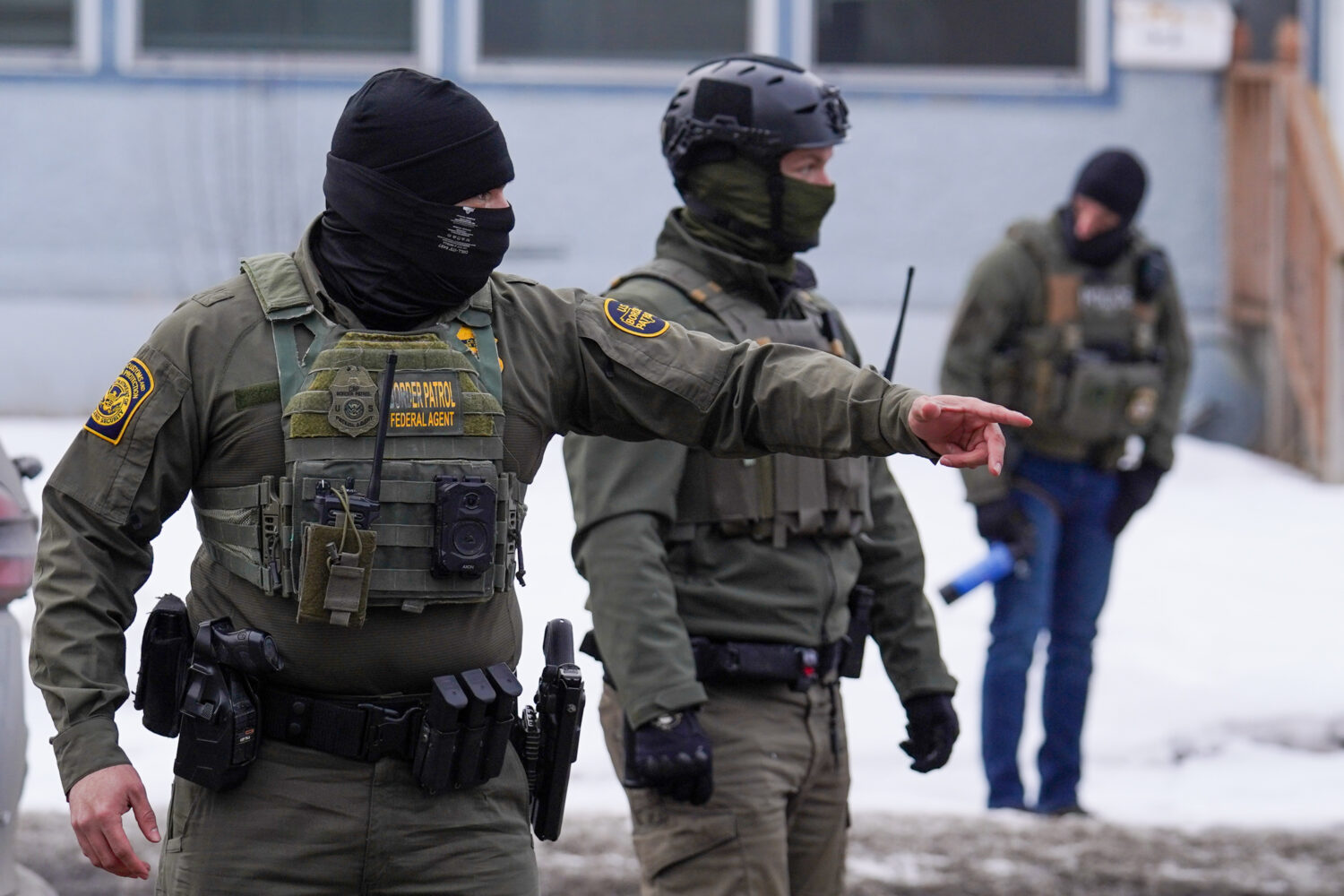 A United States Border Patrol agent gestures to a car while conducting immigration enforcement oper...
