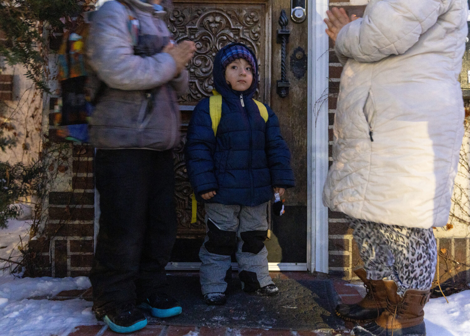 Giancarlo, 10, left, and Yair, 3, pray with their mom, right, before Giancarlo is picked up for sch...