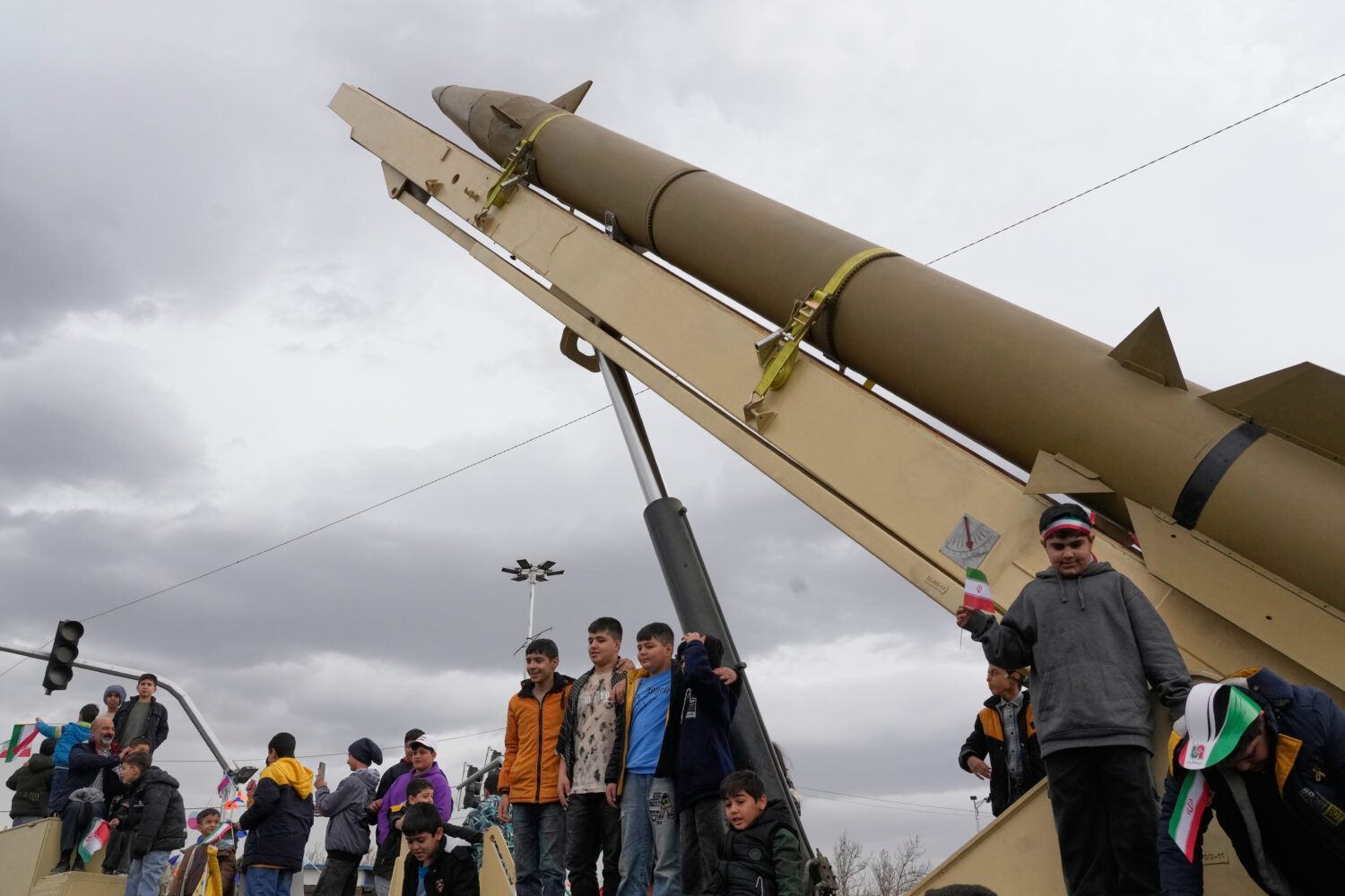 Boys stand on a launcher of an Iranian domestically-built missile during an annual rally marking 19...