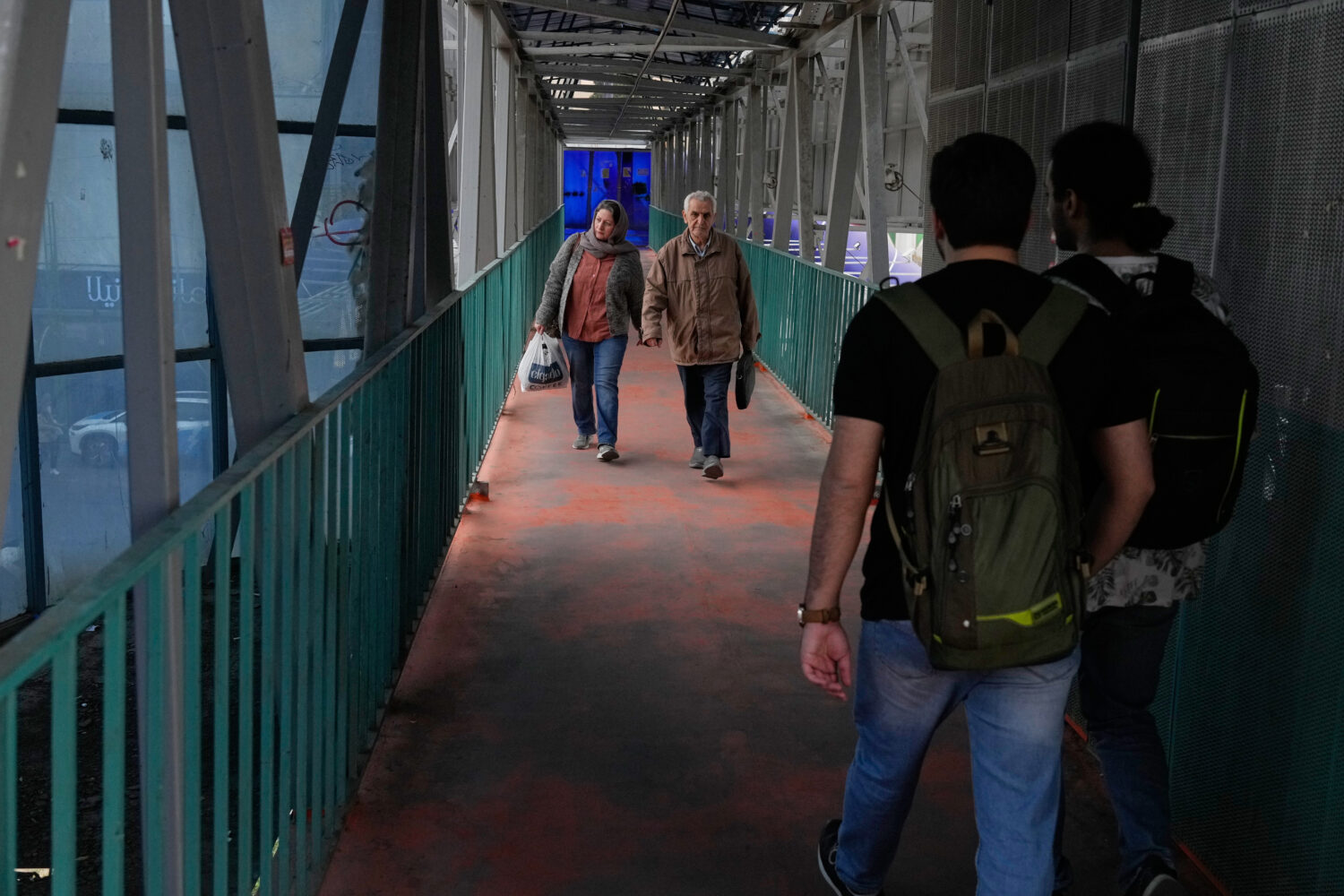 People walk across an overpass in downtown Tehran, Iran, Tuesday, Feb. 24, 2026. (AP Photo/Vahid Sa...
