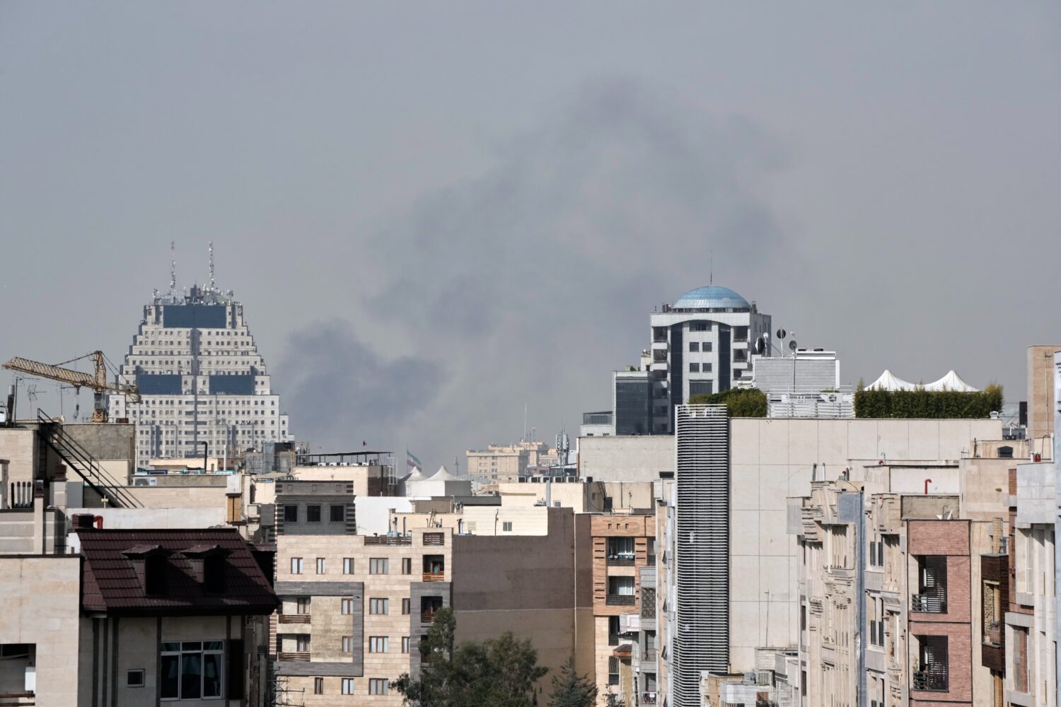 Smoke rises on the skyline after an explosion in Tehran, Iran, Saturday, Feb. 28, 2026.(AP Photo/Va...