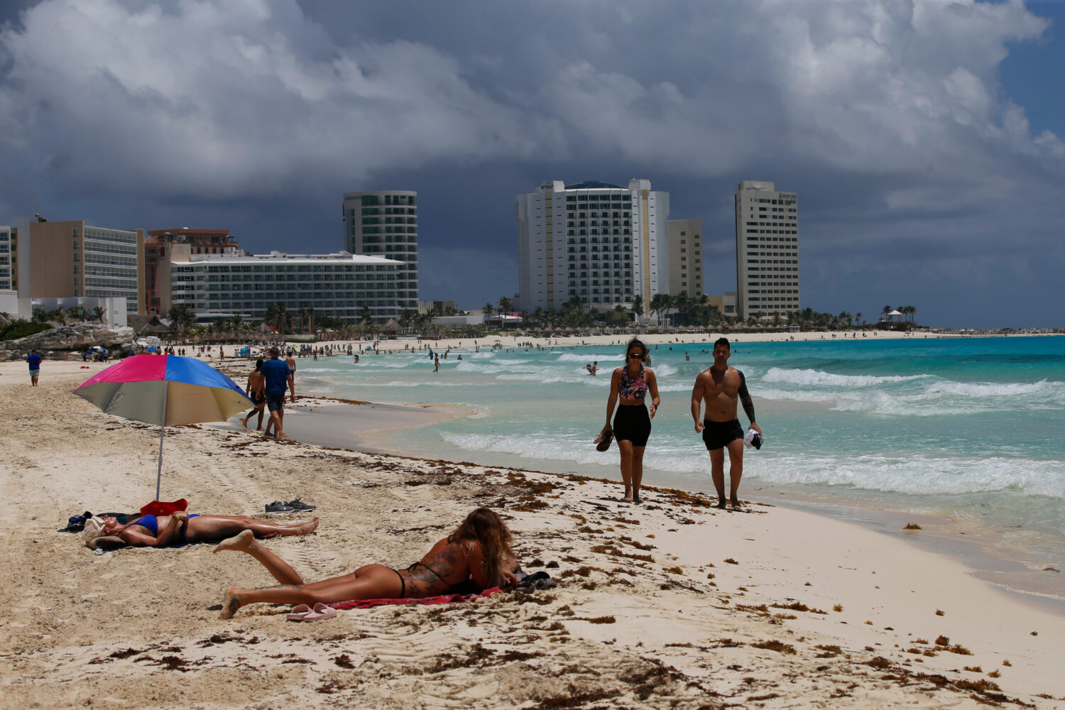 FILE - Tourists sunbathe on the beach before the arrival of Hurricane Grace, in Cancun, Quintana Ro...