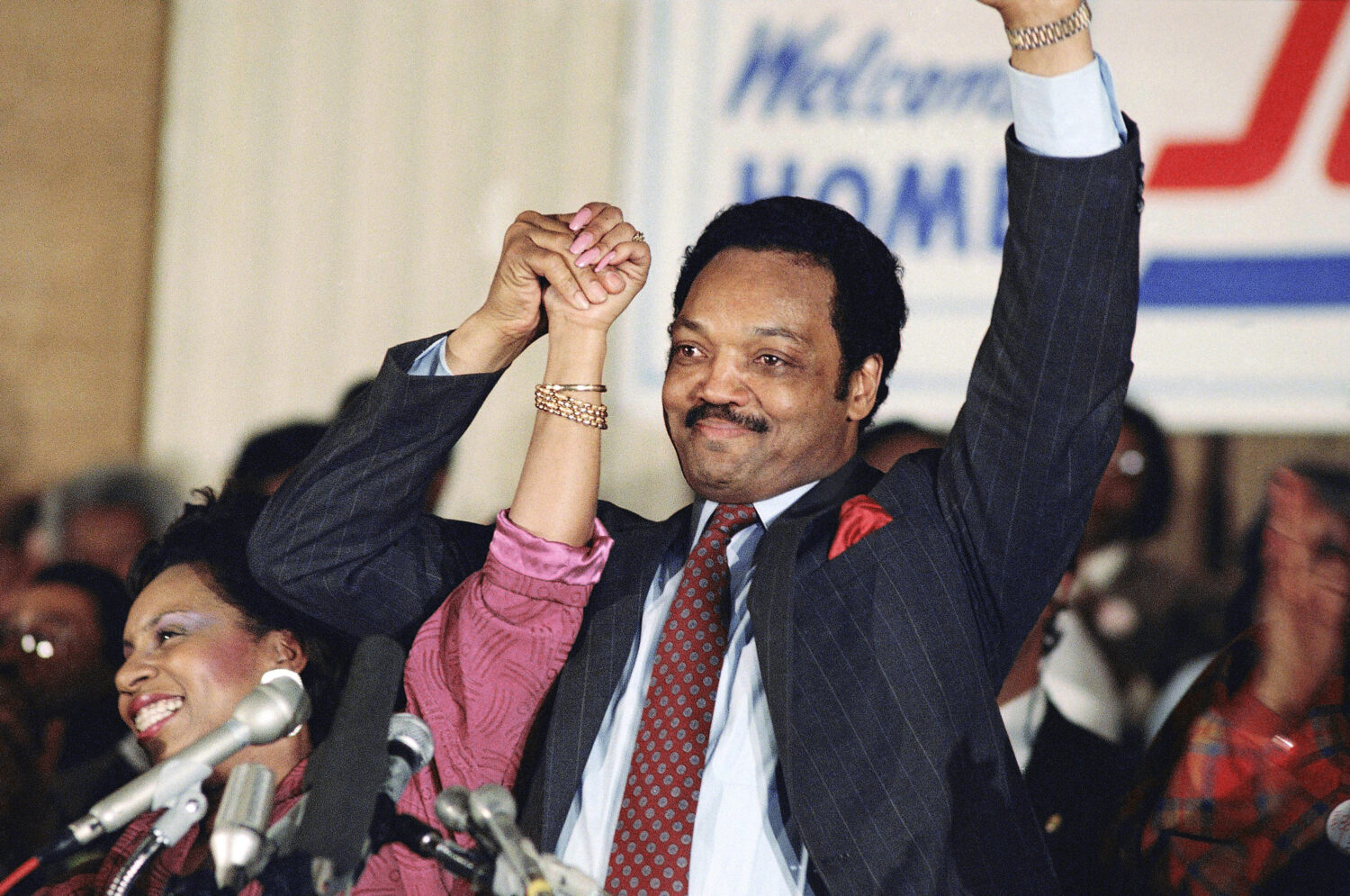 FILE - Democratic presidential hopeful Jesse Jackson with his wife, Jacqueline, salutes the cheerin...