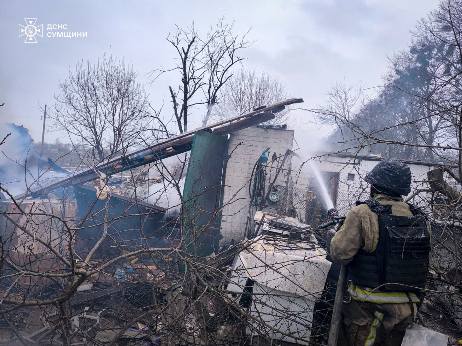 In this photo provided by the Ukrainian Emergency Service, a firefighter puts out the fire in priva...