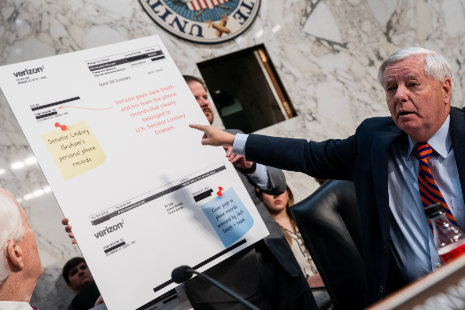 Sen. Lindsey Graham, R-S.C., points to a copy of his Verizon phone bill during a Senate Committee o...