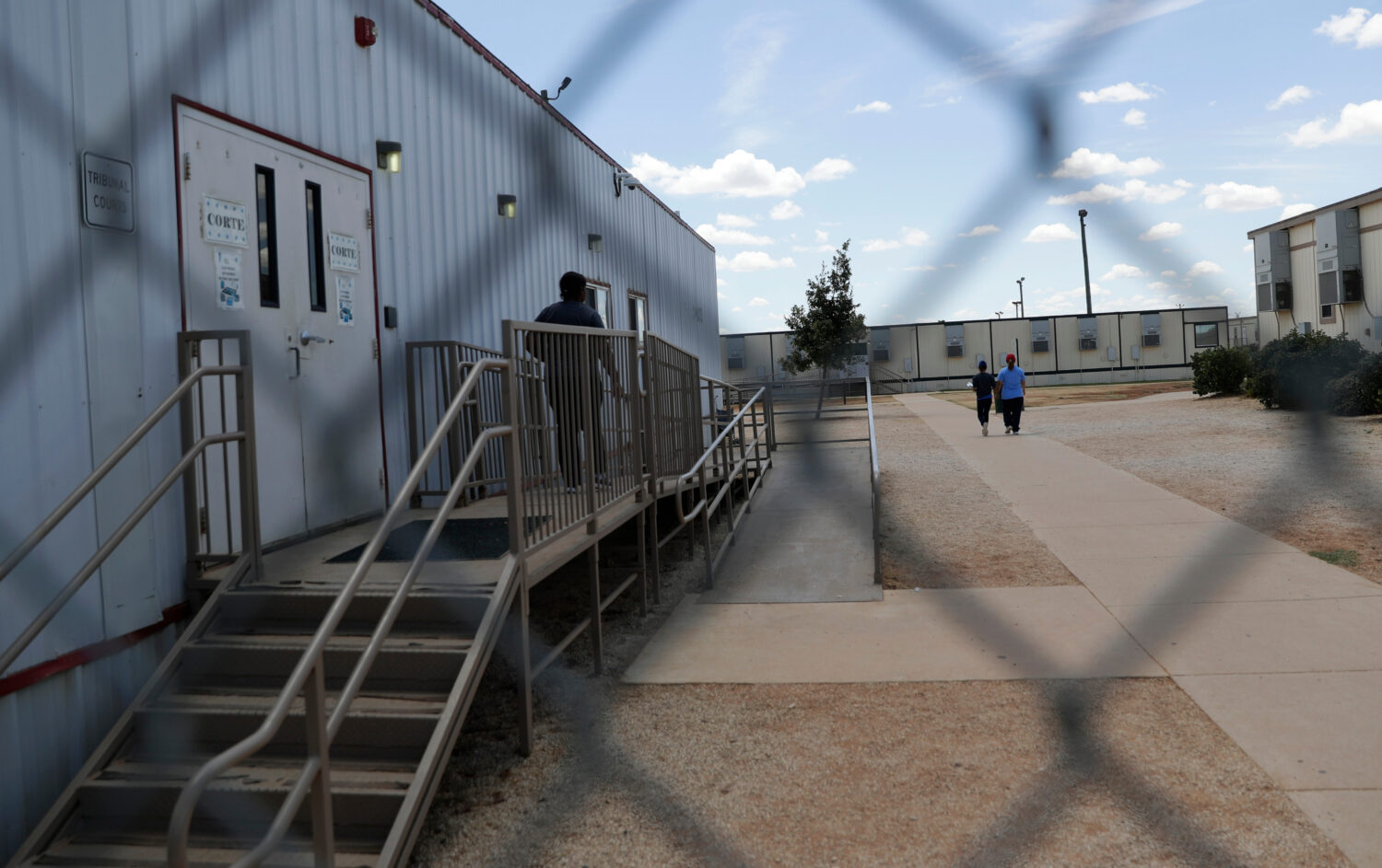FILE - Immigrants seeking asylum walk at the ICE South Texas Family Residential Center, Aug. 23, 20...