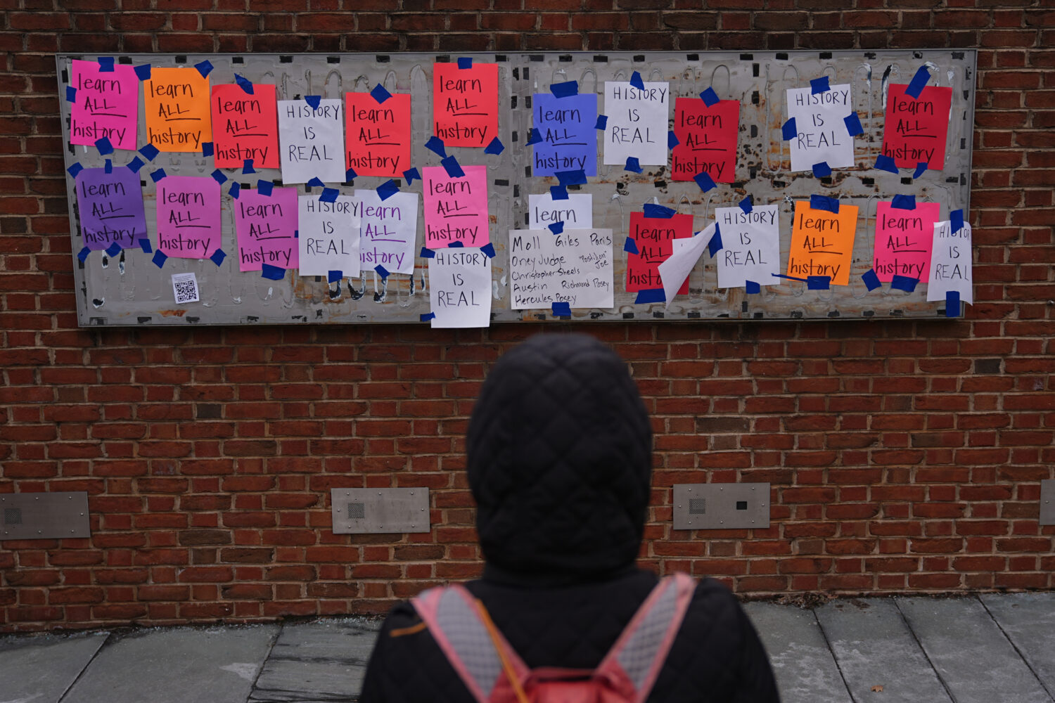 FILE - A person views posted signs on the locations of the now removed explanatory panels that were...