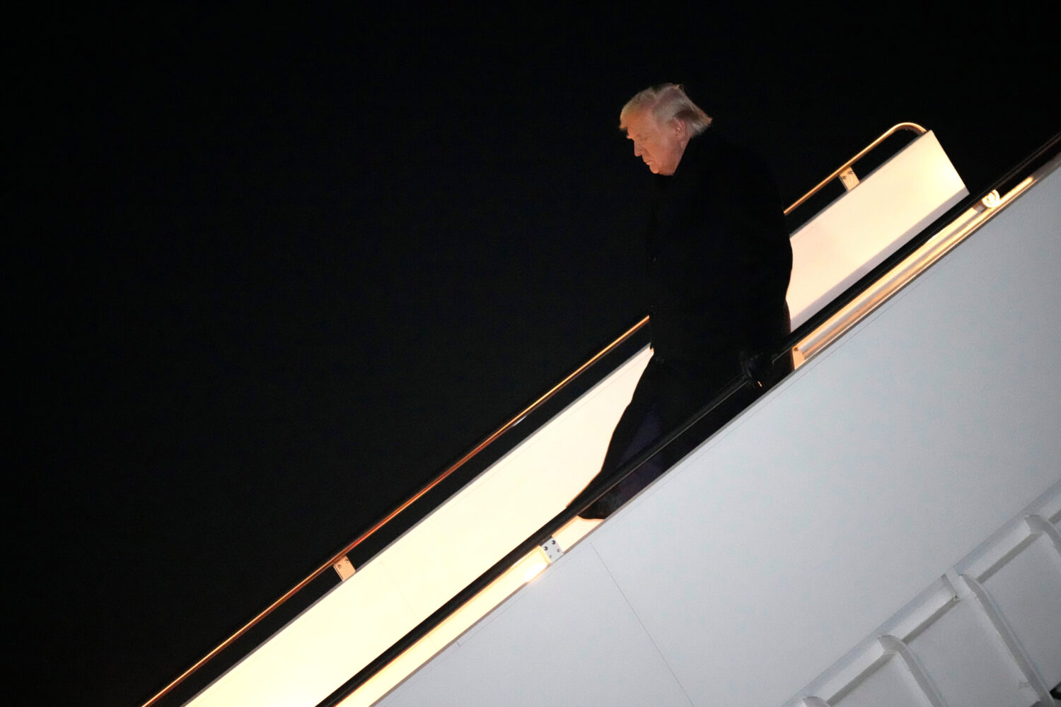 President Donald Trump steps off Air Force One, early Monday, Feb. 9, 2026, at Joint Base Andrews, ...