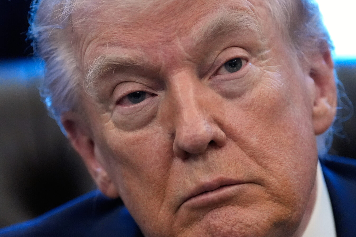 President Donald Trump listens to a question from a reporter as he speaks in the Oval Office of the...