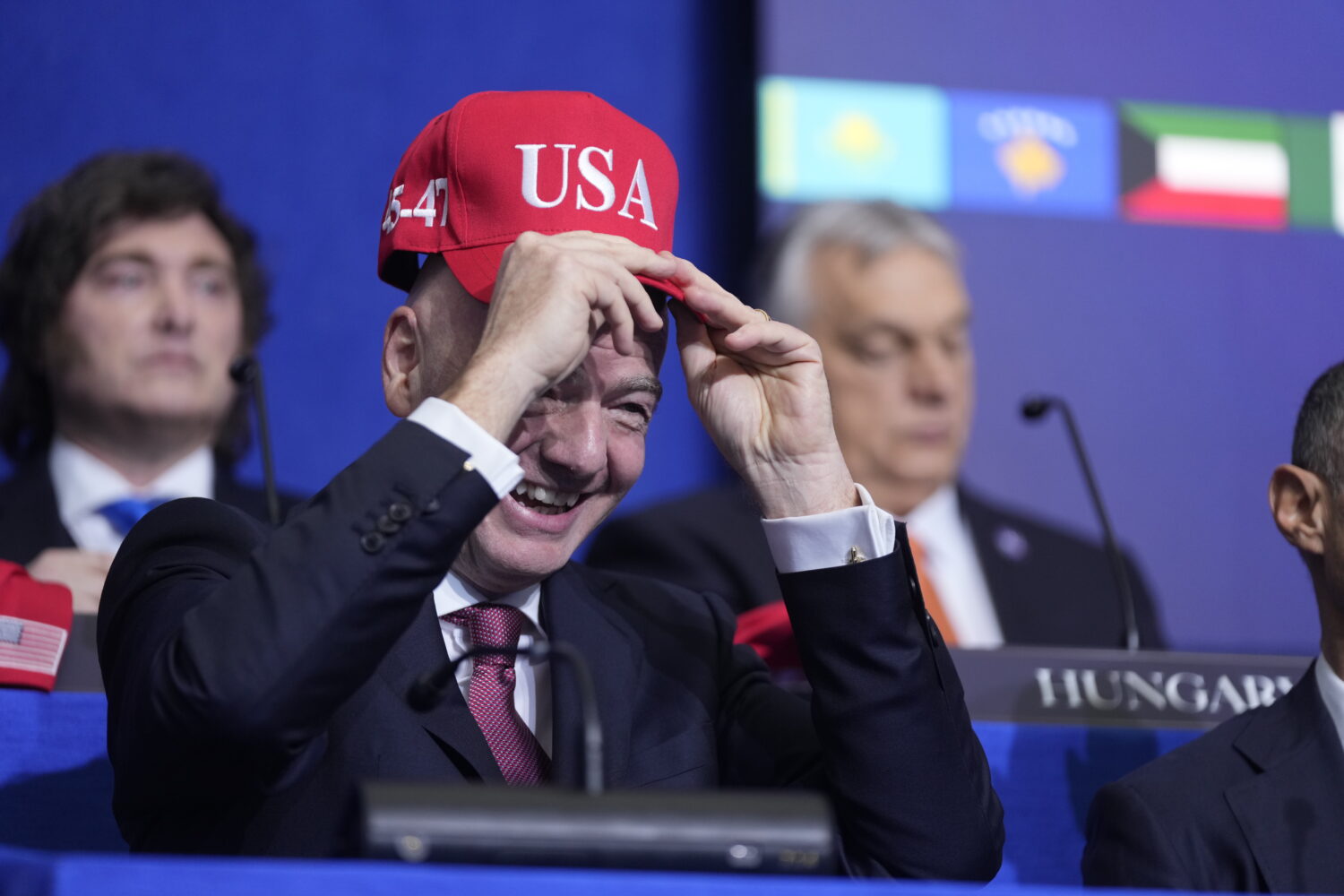 Giovanni Vincenzo Infantino, president of FIFA, tries out a USA hat during a Board of Peace meeting...