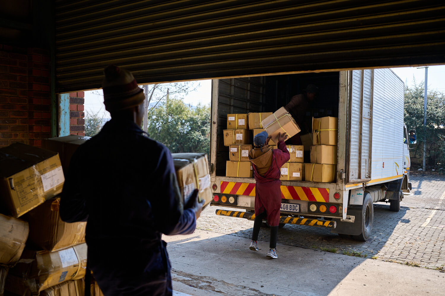FILE - Workers load a truck with the last boxes filled with clothes from the empty Tzicc clothing f...